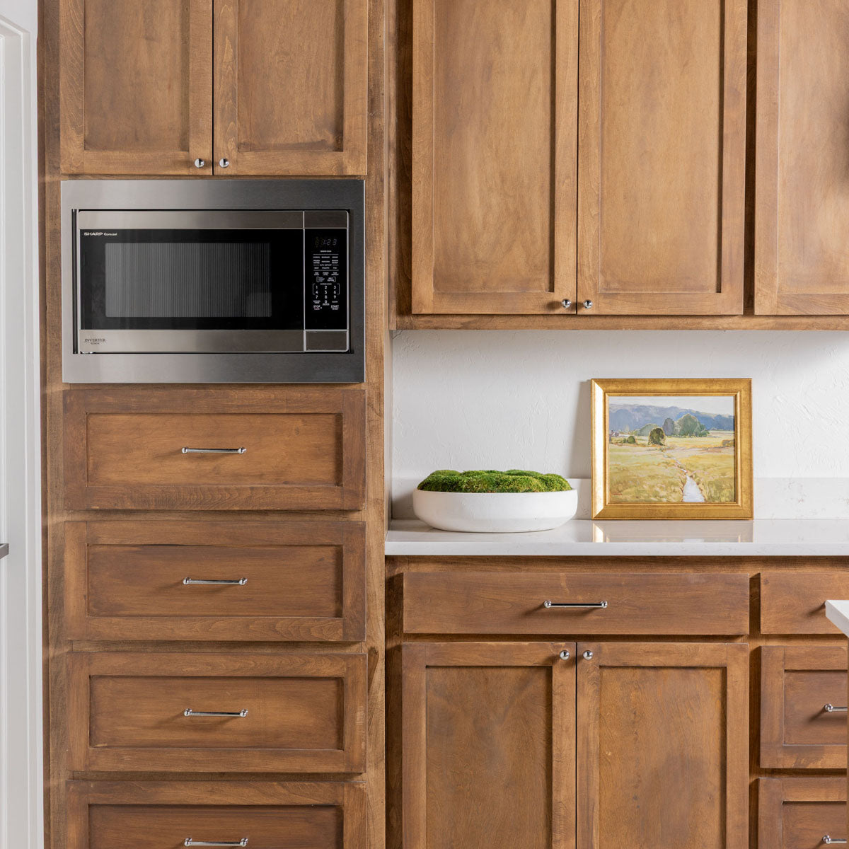 Full kitchen view of a Sharp microwave with custom built-in stainless steel trim kit for a luxury finish