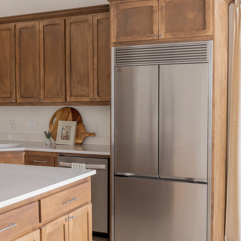 Modern kitchen highlighting a stainless steel refrigerator with customized trim kit for seamless finish