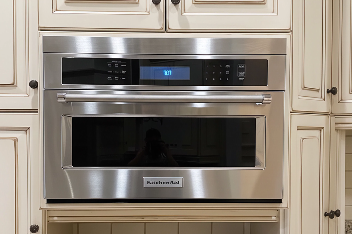 KitchenAid wall oven in beige cabinetry featuring custom-fit stainless steel filler strip to cover installation gaps for seamless finish