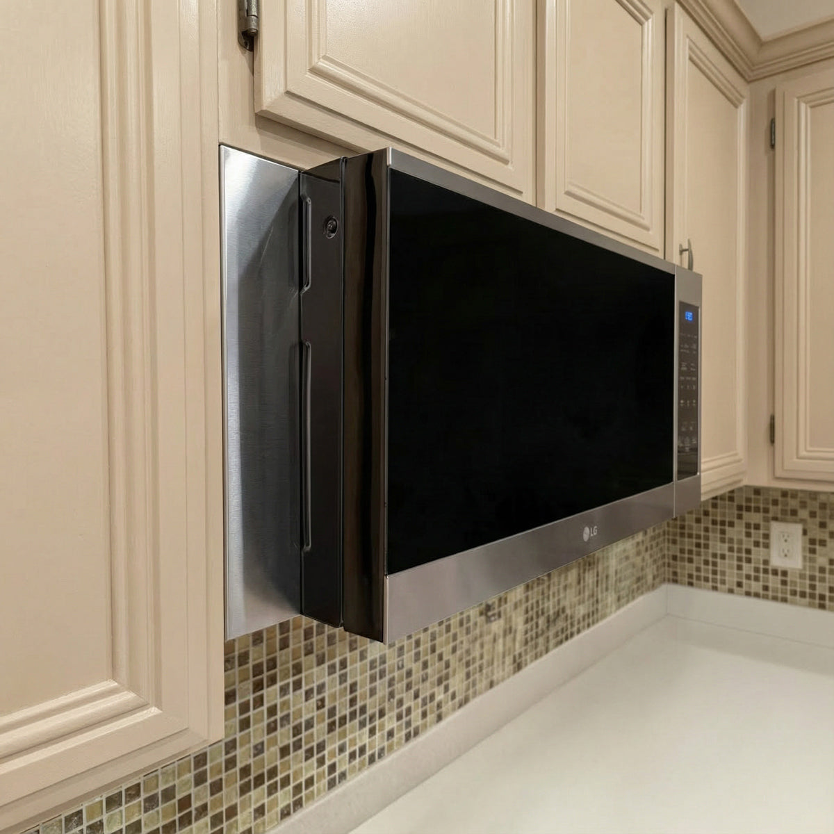 Side view of an LG over-the-range microwave with custom stainless steel filler panels covering the cabinet gap