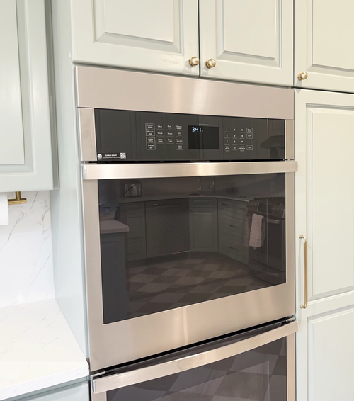 Double wall oven with custom stainless steel filler panels installed to provide a professional seamless finish in a modern kitchen